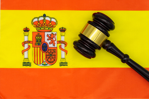 Justice in Spain. A judges gavel rests on the vibrant Spanish flag, symbolizing the countrys legal system