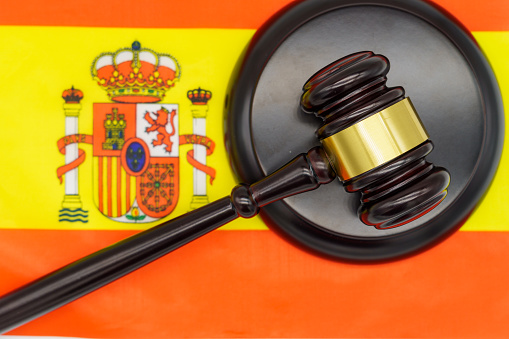Justice in Spain. A judges gavel rests on the vibrant Spanish flag, symbolizing the countrys legal system