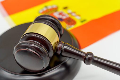 Justice in Spain. A judges gavel rests on the vibrant Spanish flag, symbolizing the countrys legal system