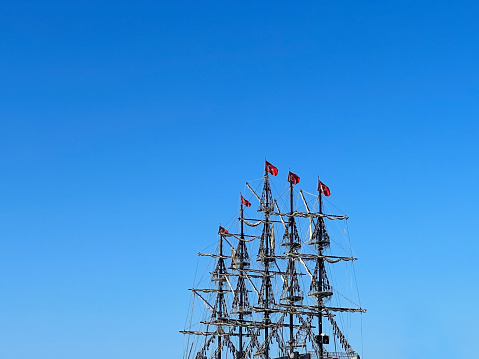 Closeup old tall ship withTurkish flags over sky in Antalya, Turkey