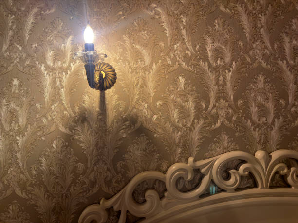 istock Close up light fixture on wallpapered bedroom wall 1990642273
