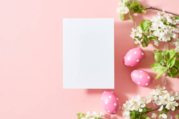 istock Mockup invitation or blank greeting card with spring flowers and easter eggs on a pink background 1990643881