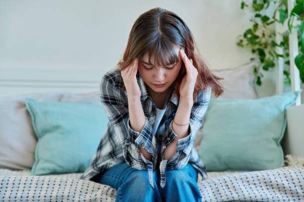 istock Upset sad young female sitting on couch at home 1990651270