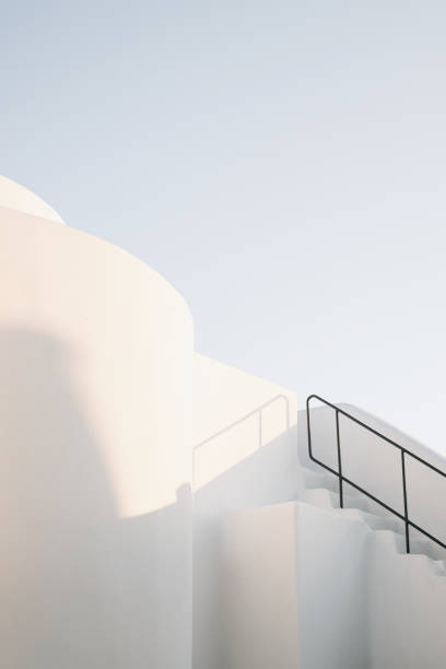 edificio blanco minimalista con barandilla metálica a la luz del día en la isla de santorini, imerovigli, grecia - bauhaus architecture fotografías e imágenes de stock