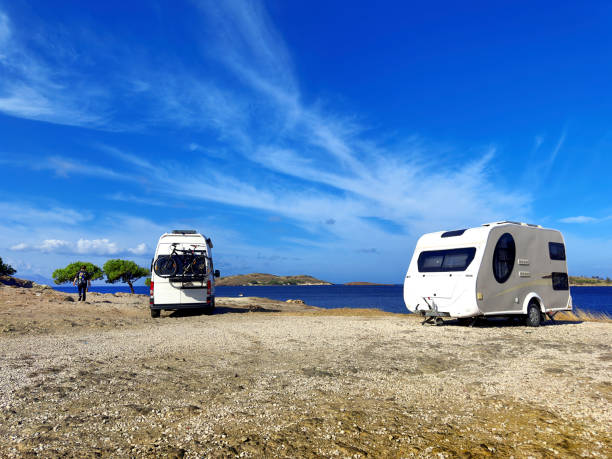 istock Camper van and camper trailer parked at sunny seaside 1990669248