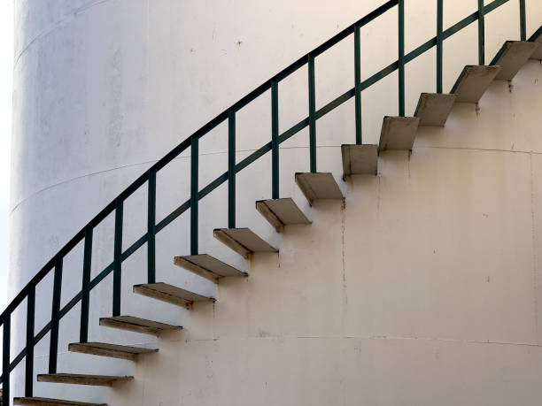 istock Large industrial cylinder storage tanks and spiral staircase 1990681827