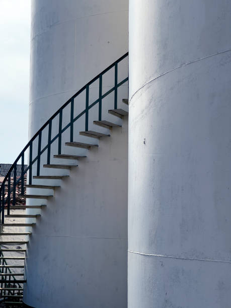 istock Large industrial cylinder storage tanks and spiral staircase 1990692662