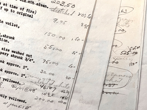 Financial figures from fire damage insurance claim on paper from 1962.