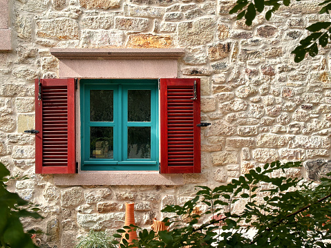 Exterior plaster wall with white window with shutters, showing interior bedroom, blank background with copy space, architecture design concept