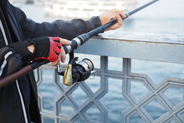 istock Fisherman with rod, spinning reel , 1990725376