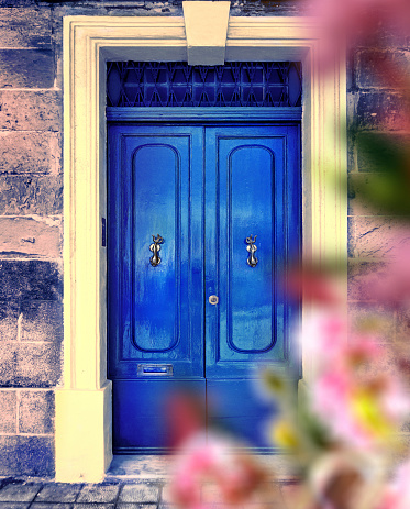 A vertical shot of a modern blue door from a brick building.