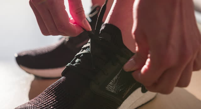 Close-up of woman tying sports shoe laces