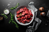 Beef meat entrecote sliced, raw beef meat fillet on black background, top view