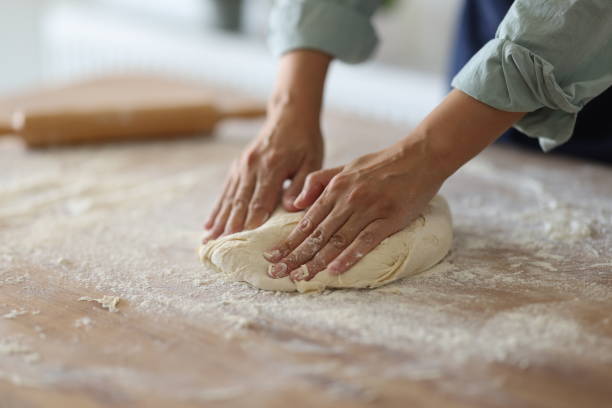 istock Female hands are kneading dough 1990778351