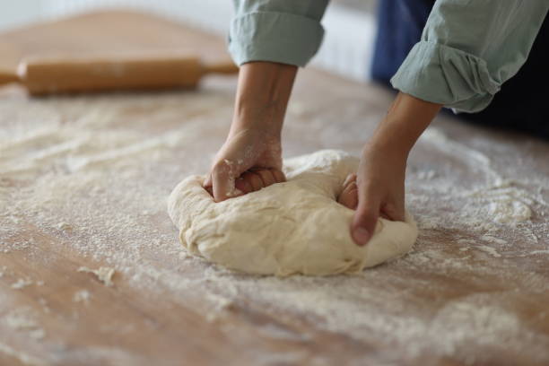 istock Female hands are kneading dough 1990778904