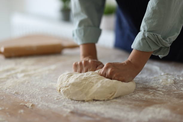 istock Female hands are kneading dough 1990779410