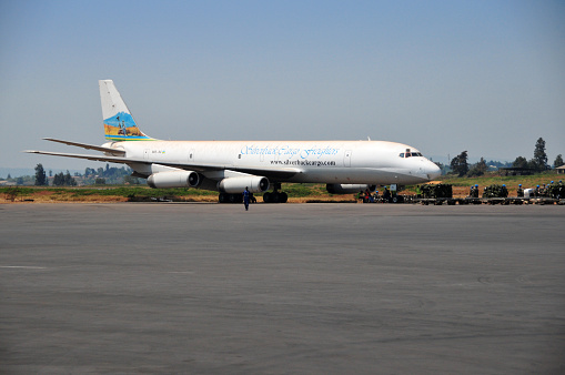 Kigali, Rwanda: Silverback Cargo Freighters, McDonnell Douglas DC-8-62H(F) long-range, all cargo, registration 9XR-SC, MSN 463, with faded paint - parked at  Kigali International Airport with UN peace-keepers and their equipment on the apron - The Douglas DC-8 is a four-engine jet passenger airliner manufactured by Douglas Aircraft Company. The DC8 is a low-wing monoplane with a conventional tailplane.
