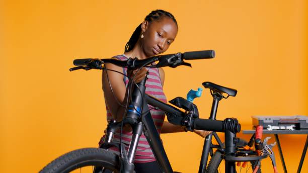 istock Mechanic setting up bike repair stand, studio background 1990868598