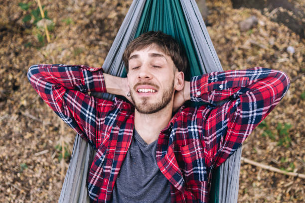 Young man resting on a hammock in the forest