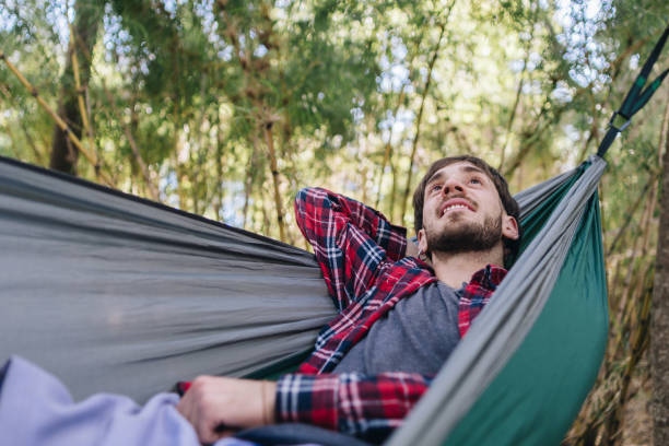 istock Young man contemplating and resting on a hammock in the forest 1990886866