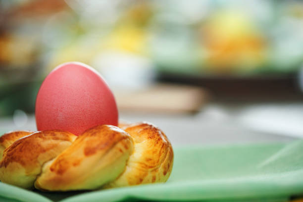 Red boiled easter eggs pile in a wooden bowl on blue background
