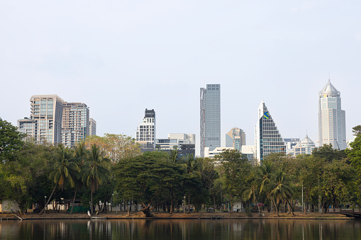 Jakarta, Indonesia - September 25, 2022: View of West Irian Liberation Monument under the blue sky and among the row of trees