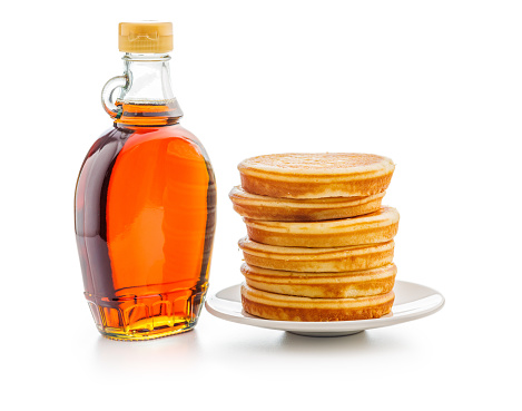 Pancakes and maple syrup in bottle isolated on the white backgorund.