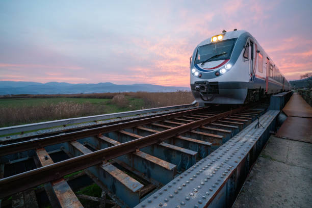 istock Train is passing on the railway bridge in a beautiful sunset view through the fields 1990920725