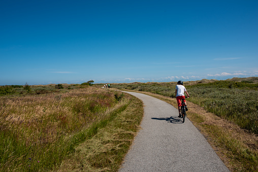 Skagen, Denmark - July 10 2019: Biking along a long bike road.