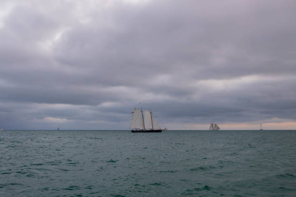 Sail boats on the horizon with stormy sky