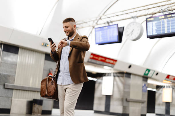 istock Man walks down the subway station and uses smart phone. 1990944842