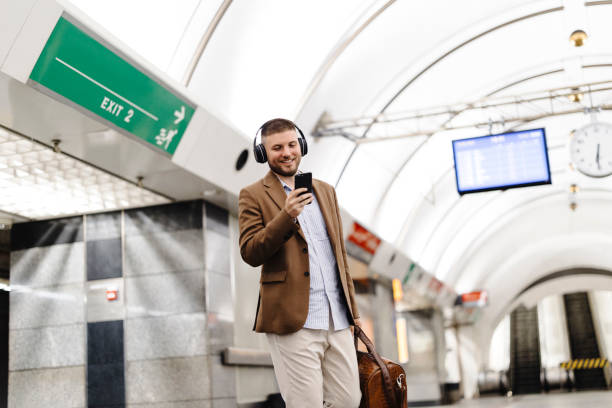 istock Man walks down the subway station and uses smart phone. 1990947527
