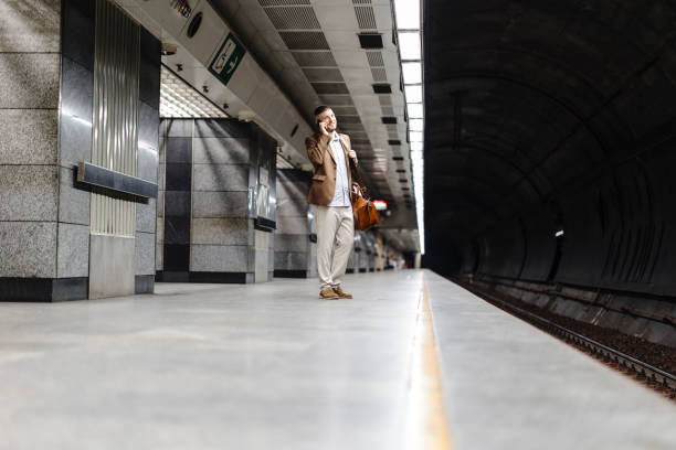 istock Man walks down the subway station and uses smart phone. 1990948040