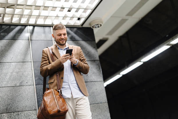 istock Man walks down the subway station and uses smart phone. 1990948047