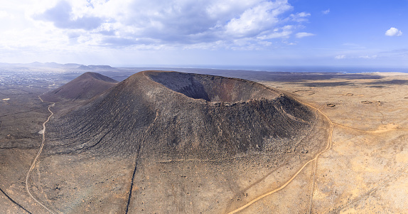 Mid aspect aerial distance panoramic image of Volcan Calderon Hondo volcano and volcanic crater near Corralejo and Lajares, Fuerteventura, Canary Islands, Spain