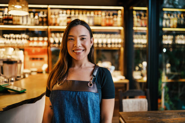 istock Smiling young bartender standing in a trendy bar 1991020890
