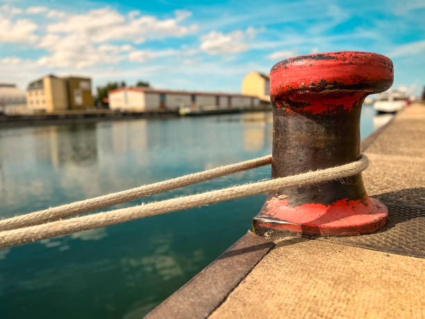 Industrial scene overlooking the Rhine River in Port de Strasbourg in France. A large ship is tied to a steel beacon.