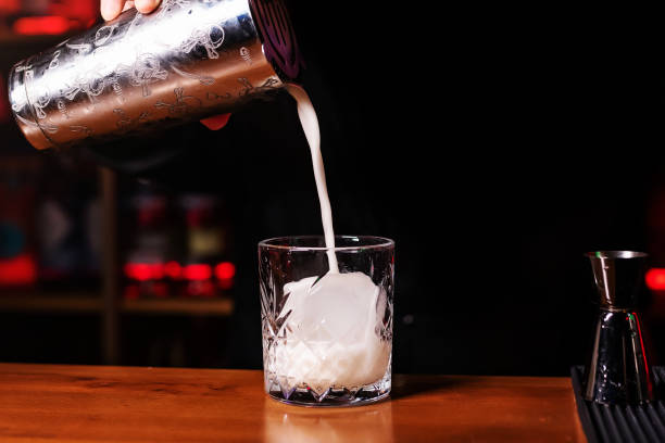 istock Bartender pours an alcoholic milkshake into a glass with ice using a shaker. Mixing an alcoholic cocktail in a nightclub, pub, restaurant 1991034833
