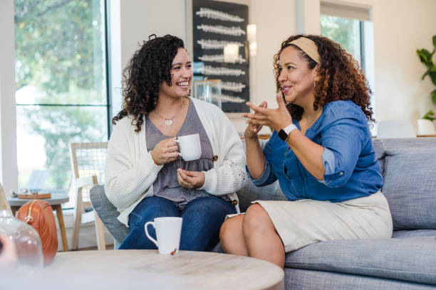 istock Young woman laughs as female friend describes experience 1991035868