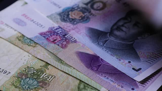 A man placing Chinese Yuan bank notes on table