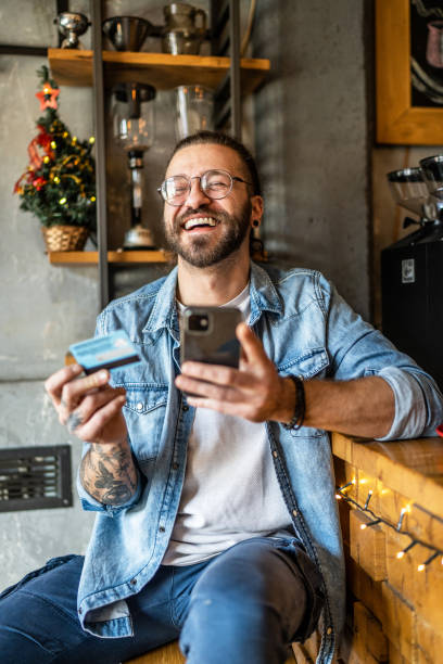 istock Smiling young man shopping online 1991080798