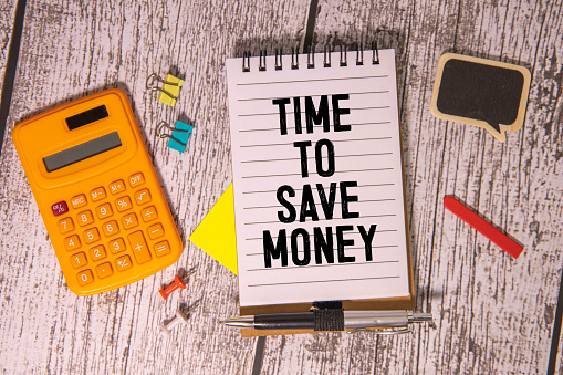 Time to save money symbol. Yellow steaky note with words Time to save money. Beautiful deep blue background. Business and Time to save money concept. Copy space.