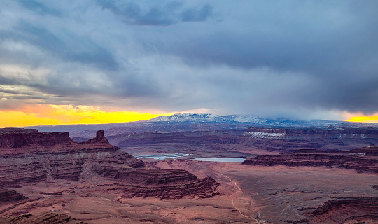 A storm moving over La Sal mountains, captured at sunrise.