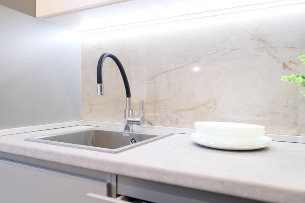 istock Modern flexible kitchen faucet. Modern classic kitchen interior with furniture 1991126189