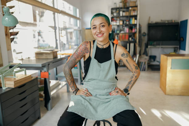 istock Creative female worker sitting on background of own design studio and looks camera 1991130327