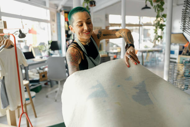 istock Creative female worker preparing screen printing film for using on printing machine in a workshop 1991136030