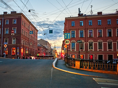 Cityscape of the evening street, old residential buildings and crossroad  in the historical center of St. Petersburg, Russia. Unrecognizable people on the sidewalk