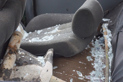 a gray chair in a piece of broken white glass in a car after an accident