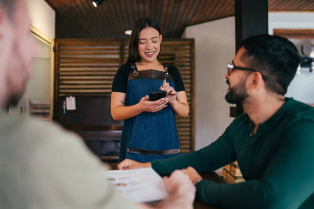 istock Gay couple ordering from a waitress in a restaurant 1991161768