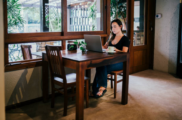 istock Young woman working remotely at a table in a cafe 1991161909